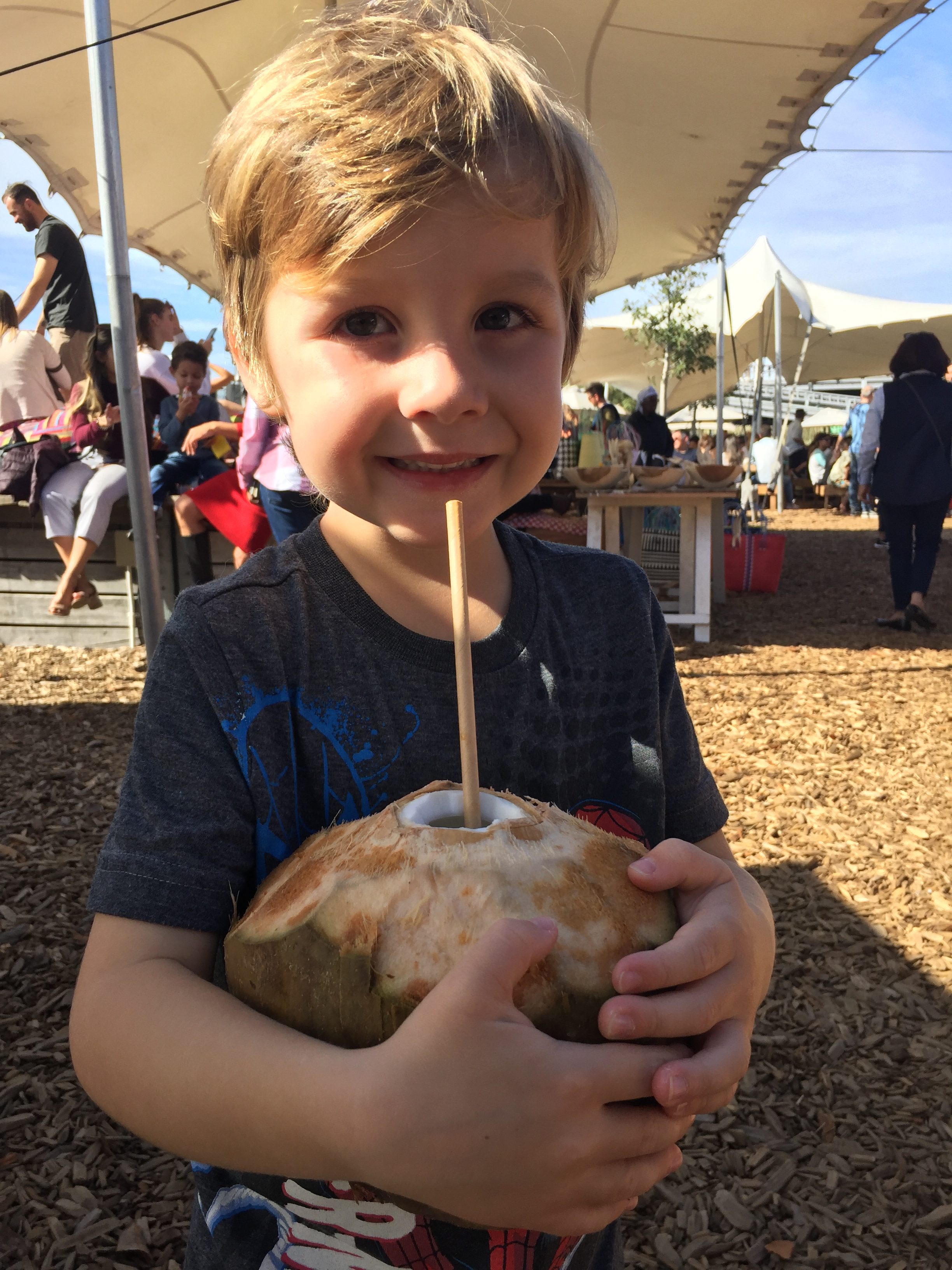 Kade with a fresh Mozambican coconut in the Granger Bay Market, Cape Town, South Africa - Copyright Great Health Naturally